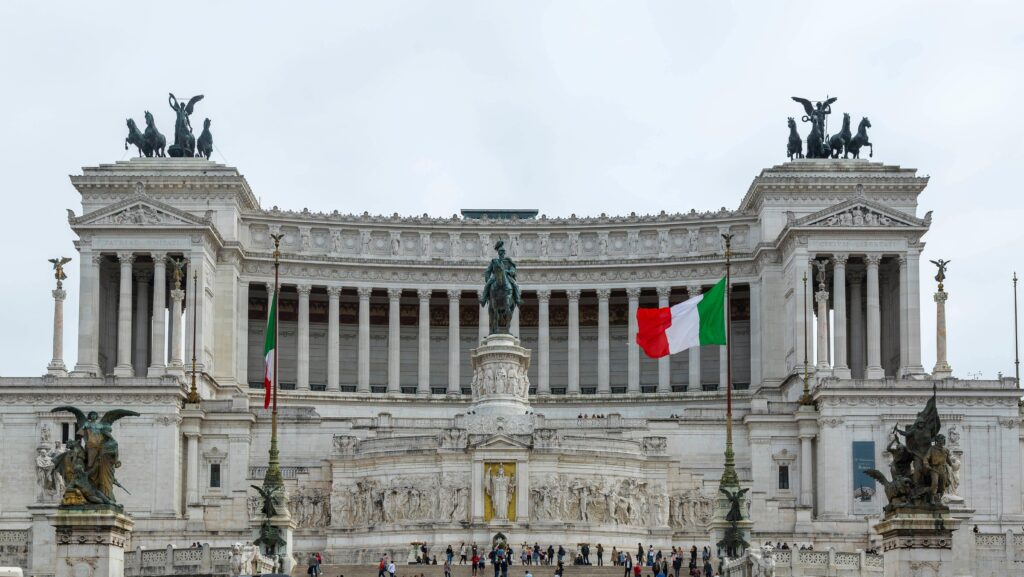 The iconic Vittoriano monument in Rome featuring Italian flags and rich architectural details.